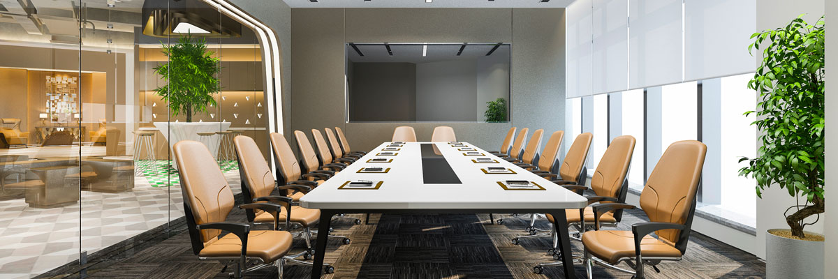 Salle de réunion avec table, chaises, écran, plantes et fenêtres.