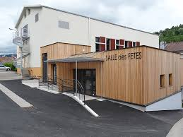 Salle polyvalente en bois avec entrée couverte et escalier.