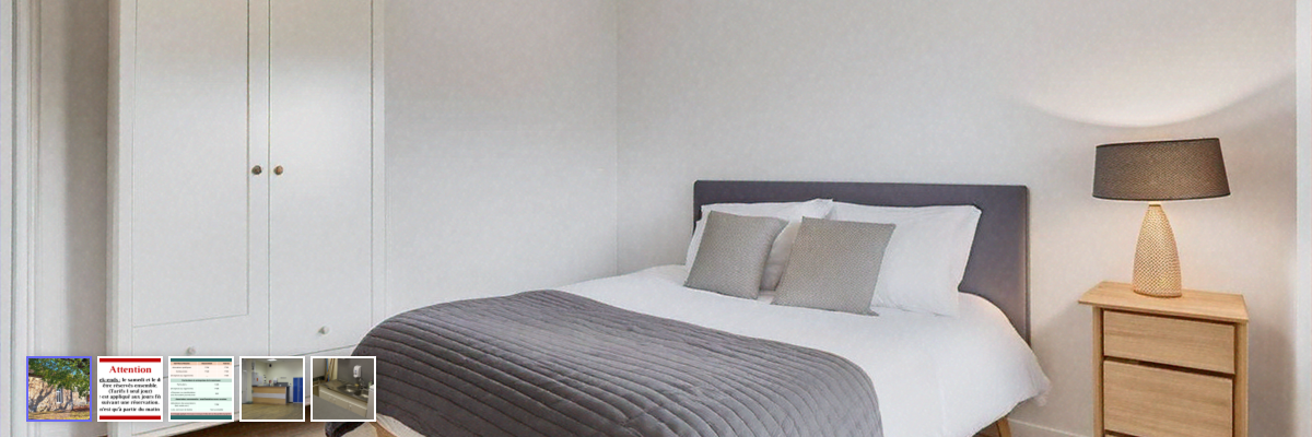 Chambre avec lit, armoire, table de chevet et lampe.