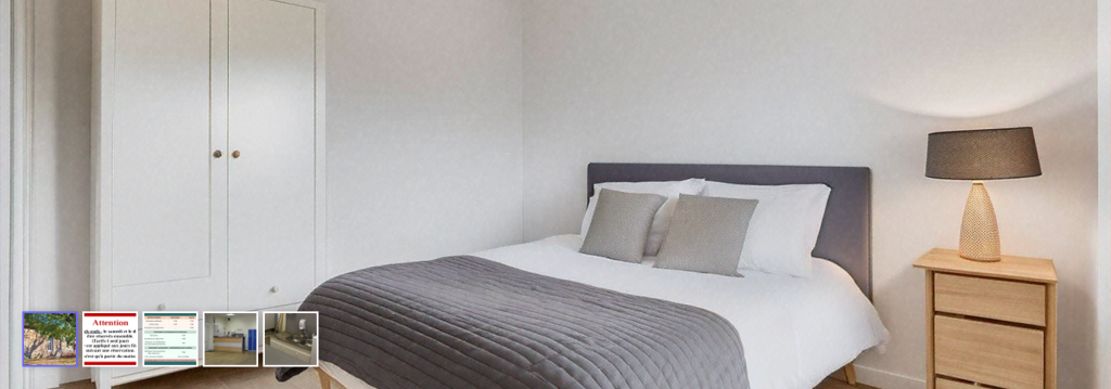 Chambre avec lit, armoire, table de chevet et lampe.